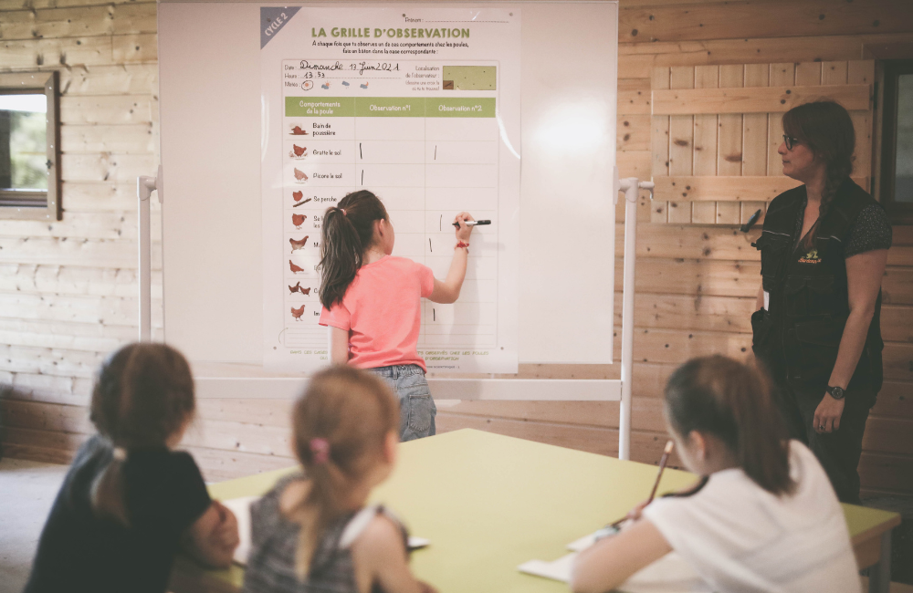 Une jeune élève écrit sur un tableau.