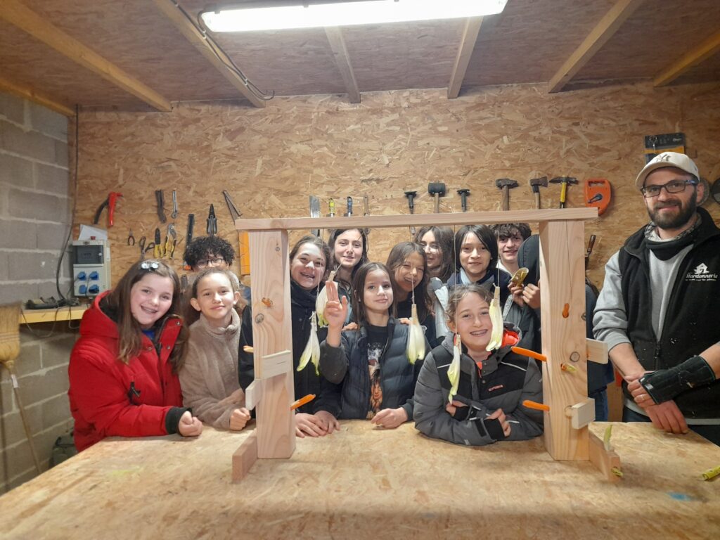 élèves de l'école de Meudon réunis autour de l'atelier de La Hardonnerie pour fabriquer des enrichissements pour le milieu de vie des lapins.